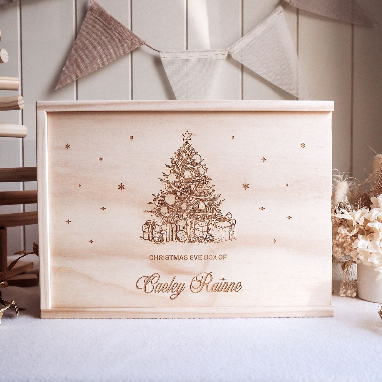 Wooden Christmas Eve box with decorative tree and gift design on a light background