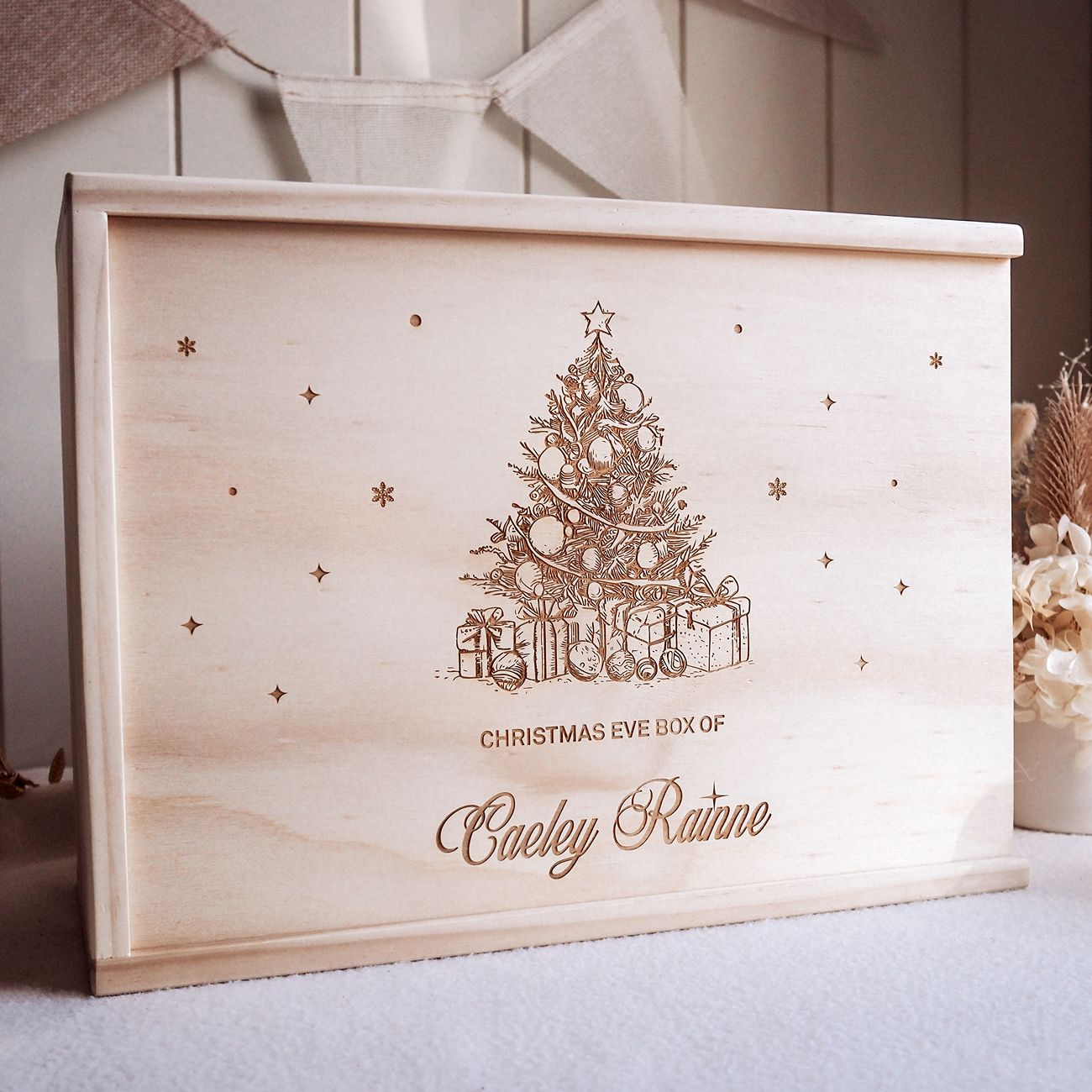 Wooden Christmas Eve box with engraved Christmas tree and presents design, featuring the name 'Caeley Rainne'.
