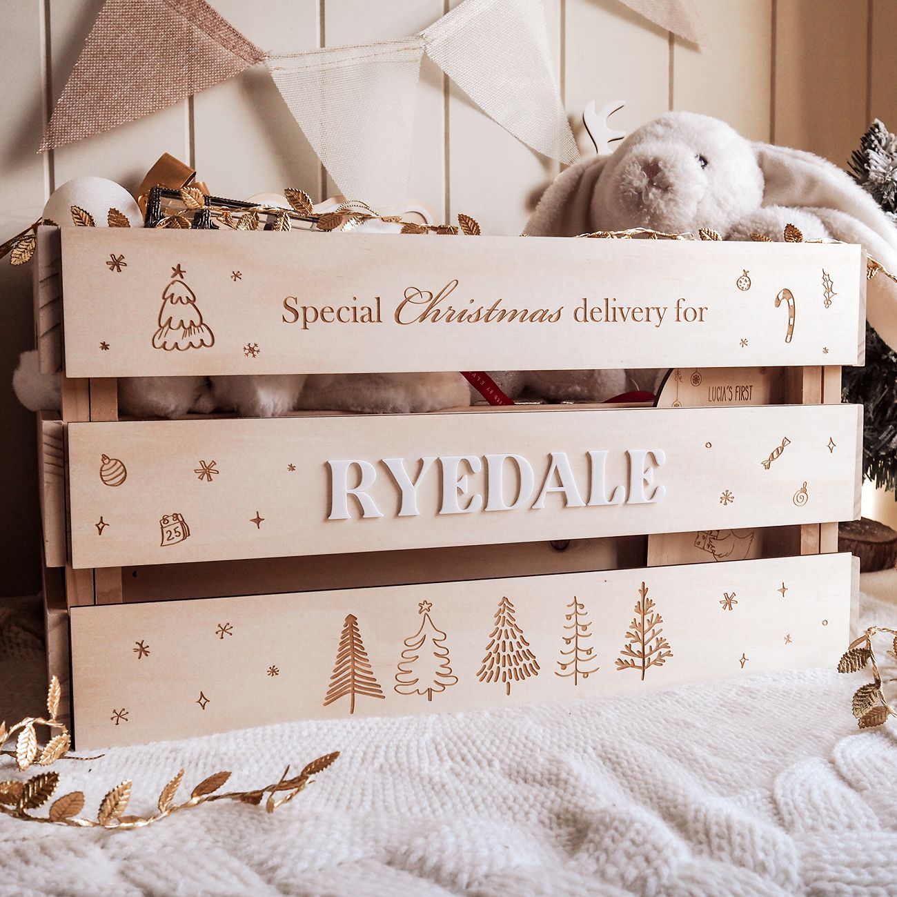 Wooden crate with 'Special Christmas delivery for Ryedale' text and decorative elements on a soft surface.