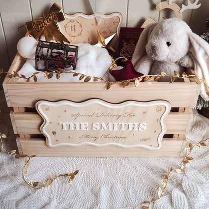 Wooden gift box with 'Special Delivery for THE SMITHS' label, stuffed bunny, and decorative items on a soft surface.