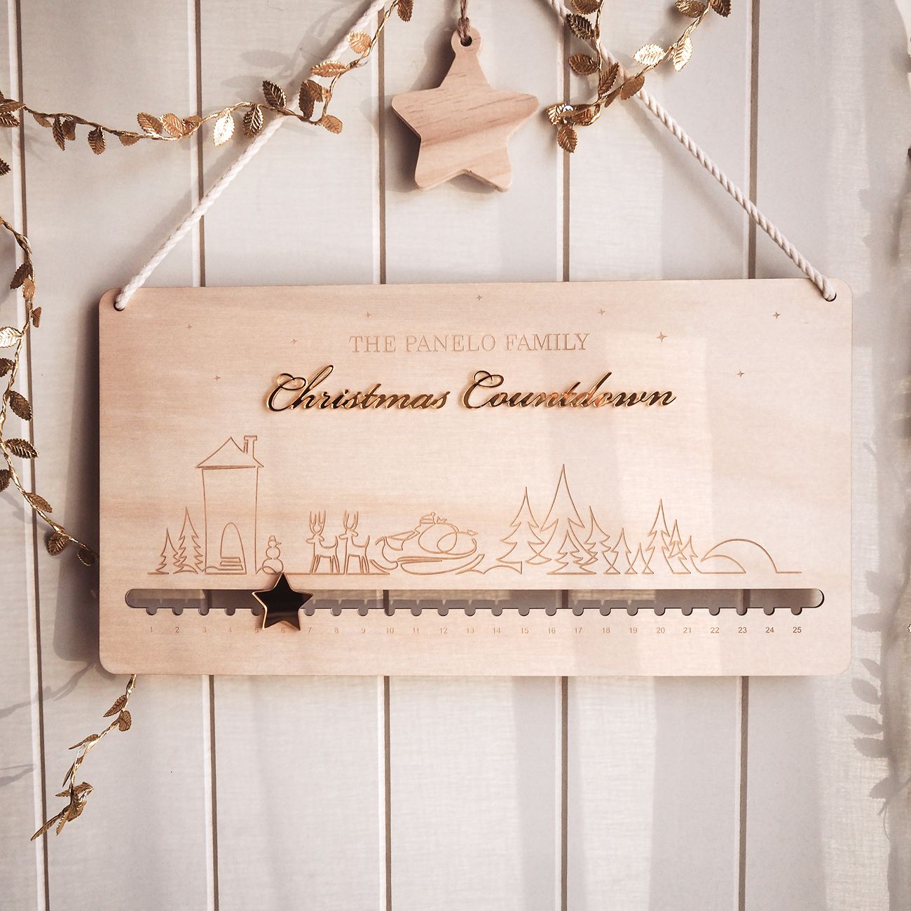 Wooden Christmas countdown calendar with decorative elements on a white wooden background