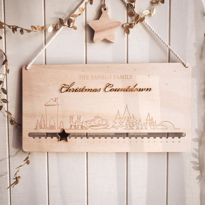 Wooden Christmas countdown calendar with decorative elements on a white wooden background