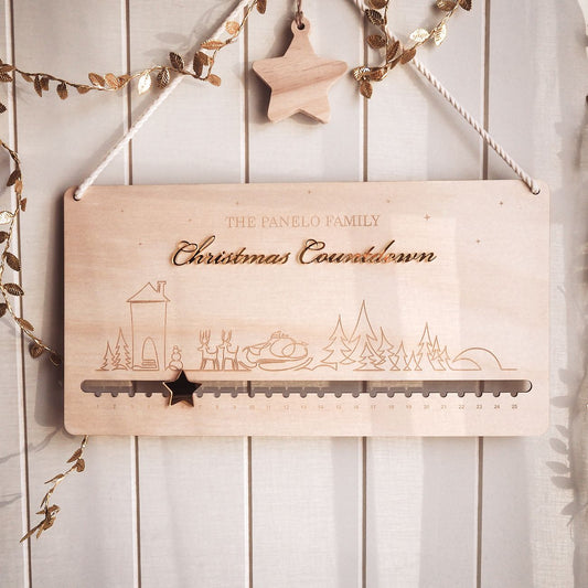 Wooden Christmas countdown calendar with decorative elements on a white wooden background