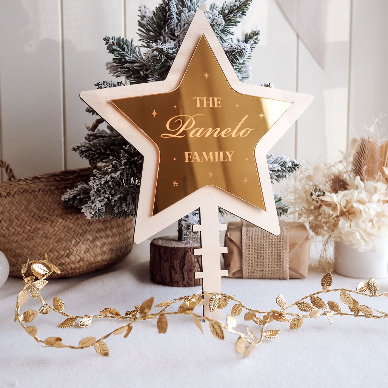 Decorative star with 'The Panelo Family' text in a festive setting with Christmas tree and decorations.