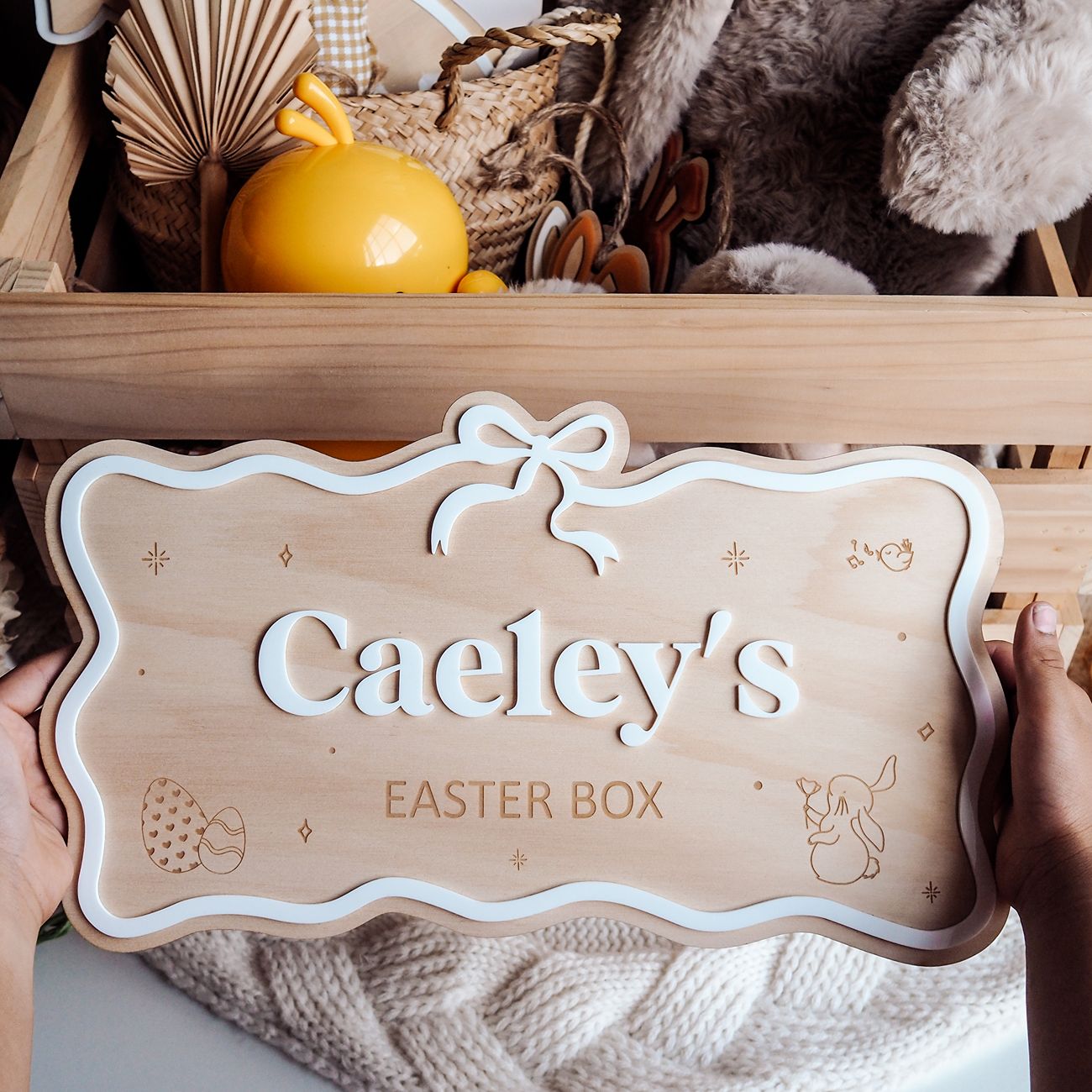 Wooden Easter box with 'Caeley's Easter Box' sign, surrounded by Easter decorations.