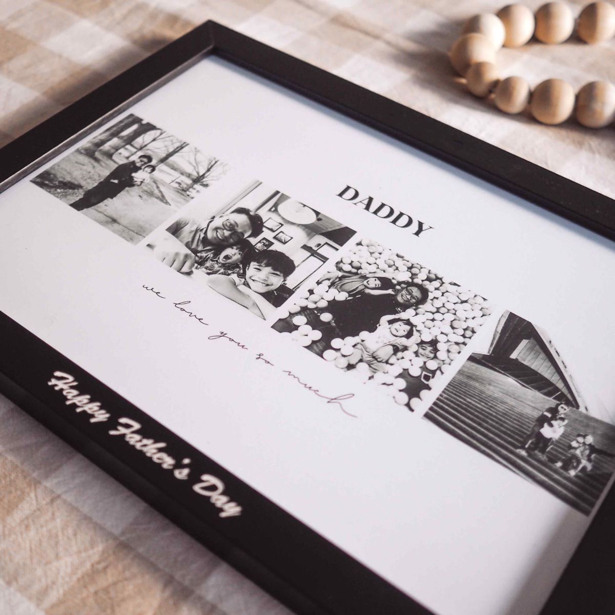 A 4 photo collage in landscape orientation with the writing of DADDY on top, then 4 photos and at the bottom of the picture is the phrase we love you so much. The frame is black with white print of "Happy Father's Day". Side view photo