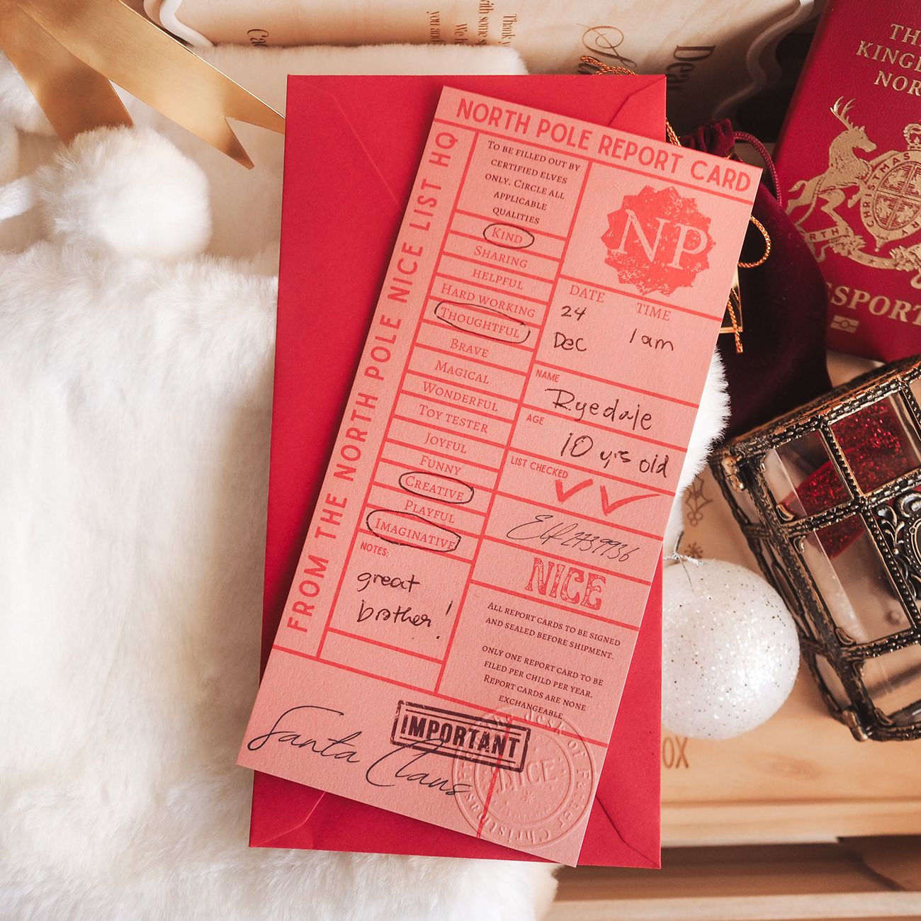 Red North Pole Report Card with Santa Claus signature on a fluffy white surface
