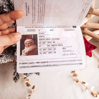 Santa Claus passport held by a hand with Christmas decorations in the background