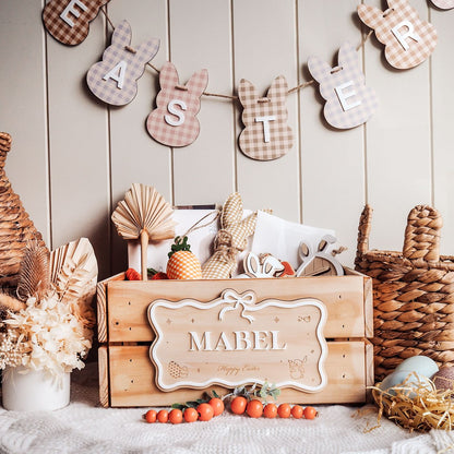 Decorative Easter setup with a wooden crate labeled 'Mabel', Easter eggs, and bunny-shaped letter decorations.
