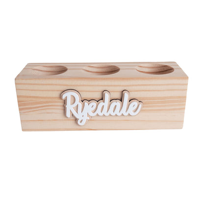 wooden pencil holder with three hole compartments. It is storing pencils, colour pencils and markers. It is also personalised. Item is on a clear background